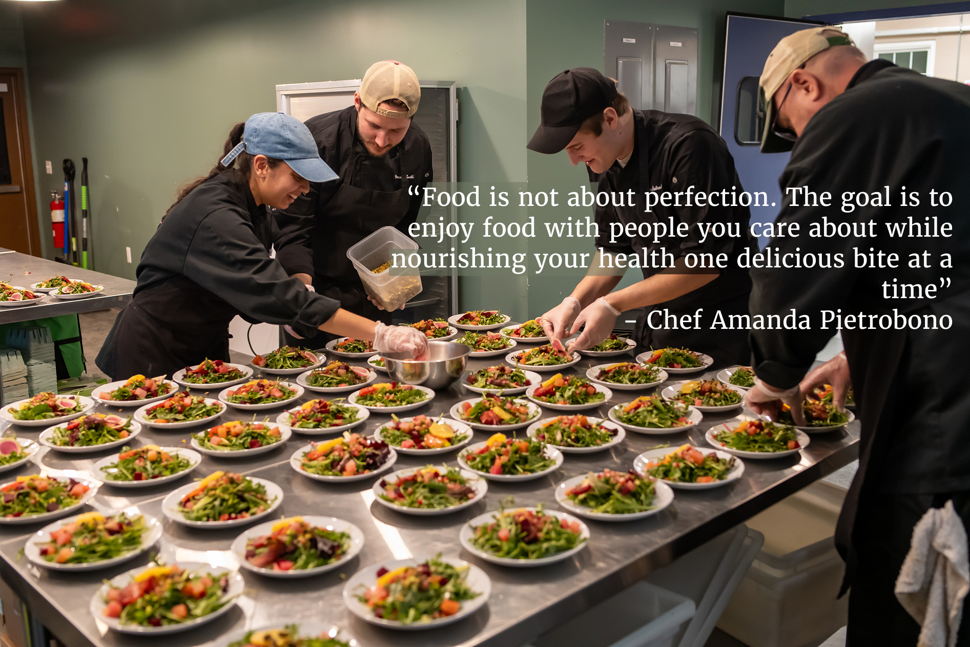 a team of kellyn volunteers preparing an array of salad plates in a kitchen