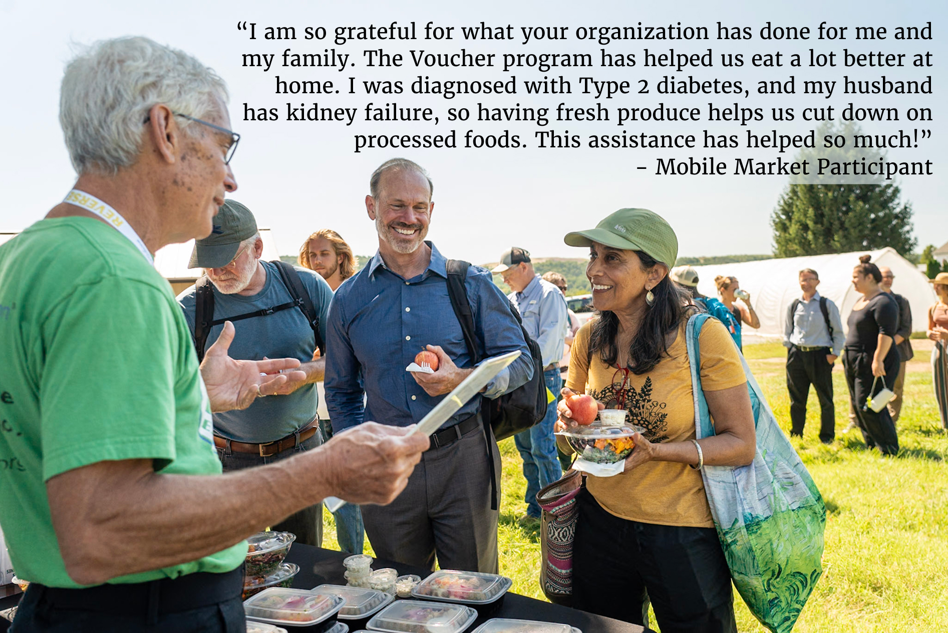 a kellyn volunteer talking to two kellyn participants at a mobile market